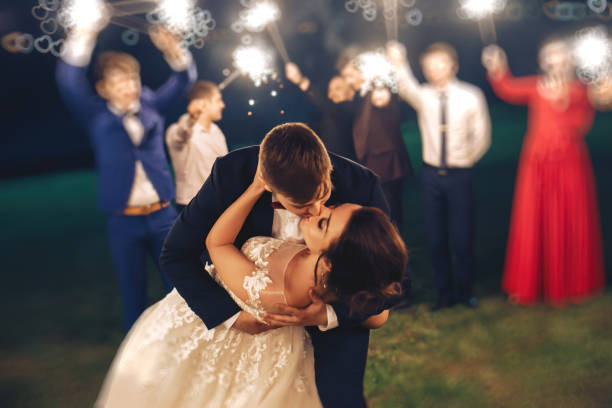 istock Groom kissing bride during evening wedding ceremony in nature 1020255856