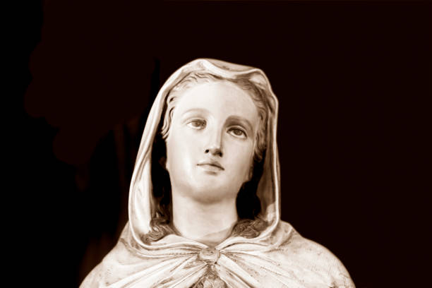 Virgin Mary, old statue, dark background with copy space Virgin Mary, old statue from cemetery build in 1872 Czech Republic, dark background with copy space, full frame horizontal composition church black and white people praying stock pictures, royalty-free photos & images