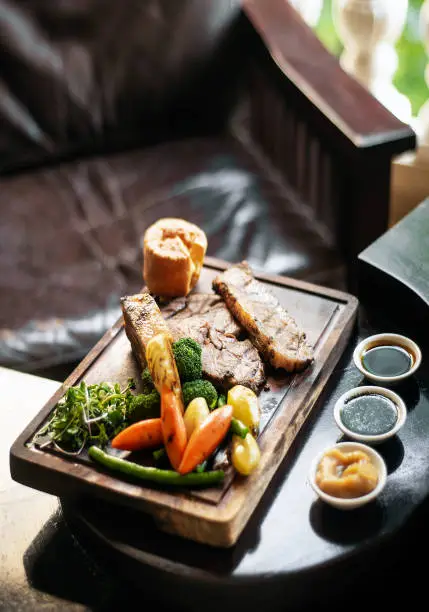 Photo of gourmet sunday roast beef traditional british meal set on old wooden pub table