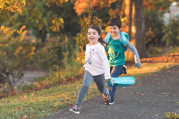 istock Elementary-age siblings running to school with their backpacks 1020307282
