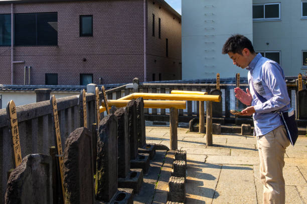 Unidentified Japanese male pay respect to  47 ronin grave at Sengakuji Temple Tokyo, Japan - April 20 2018: Unidentified Japanese male pay respect to  47 ronin grave, the 47 loyal masterless samurai, one of the most popular Japanese historical epic legends at Sengakuji Temple harakiri photos stock pictures, royalty-free photos & images