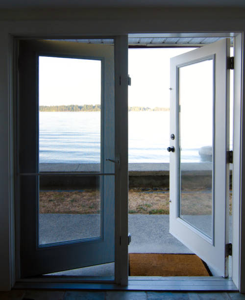 Opened french doors leading to a beach near Saanich Inlet, British Columbia stock photo