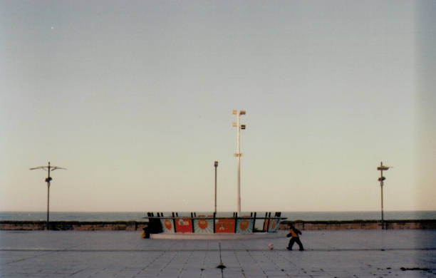 Mar del plata, buenos aires, argentina\nJanuary 2016\n\nA man sitting at a rounded bench at sunset.\nsea horizon on the back