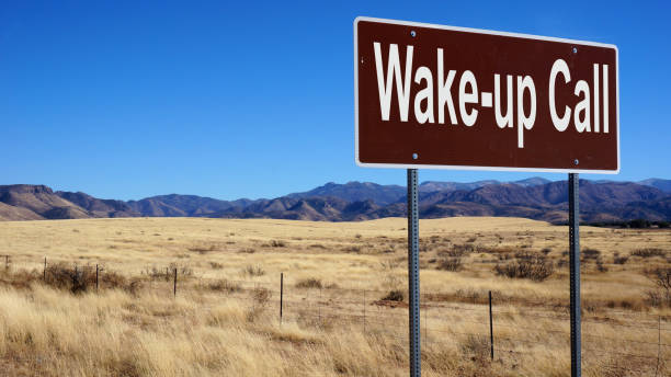 istock Wake up Call road sign with blue sky and wilderness 1020359232