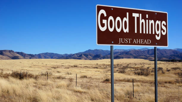 Good Things Just Ahead brown road sign with blue sky