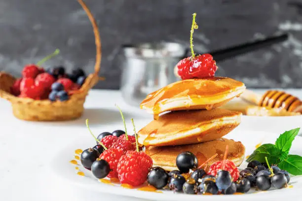 Pancake stack with maple syrup and fresh berrys. Healthy breakfast for children and vegetarians