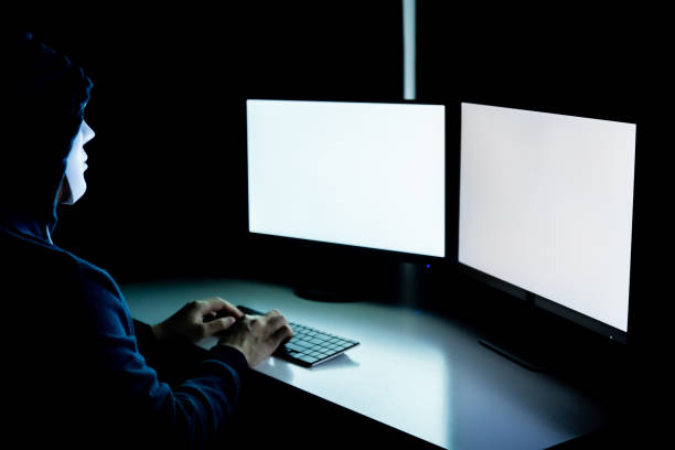 istock Anonymous and masked hacker using computer with isolated white monitor screen to insert any text, word, pictures - online cyber crime concept. 1020375628