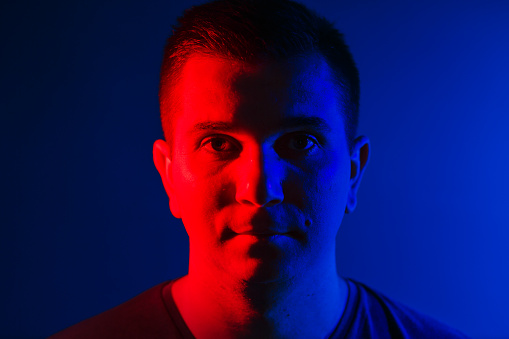 young man close head portrait red blue double colors light.