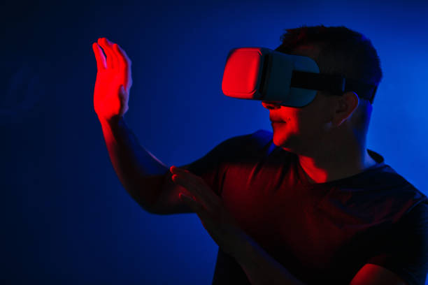 istock Scared young man in vr 3d glasses on dark background with red blue lighting 1020403608