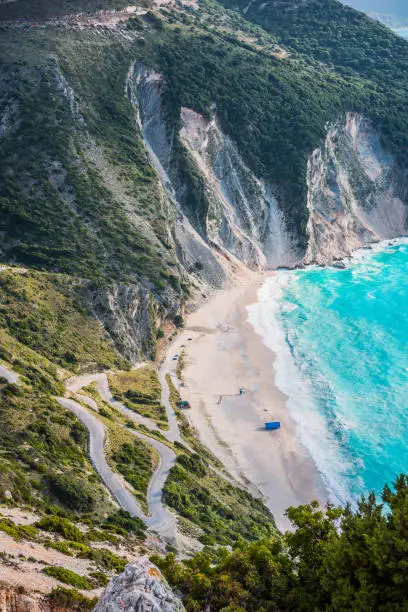 Tourist tent on famous Myrtos Beach. Big foam waves rolling towards the bay. Kefalonia, Greece.