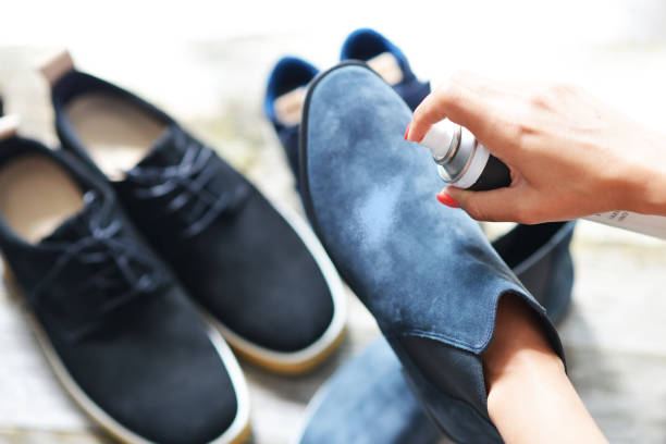 Shoes care concept with woman hands spraying leather shoe Shoes care concept with woman hands spraying leather shoe suede stock pictures, royalty-free photos & images