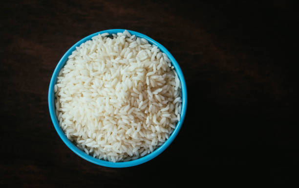 istock cup of white rice on dark wooden table 1020447390