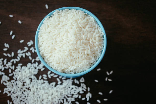 istock cup of white rice on dark wooden table 1020447396