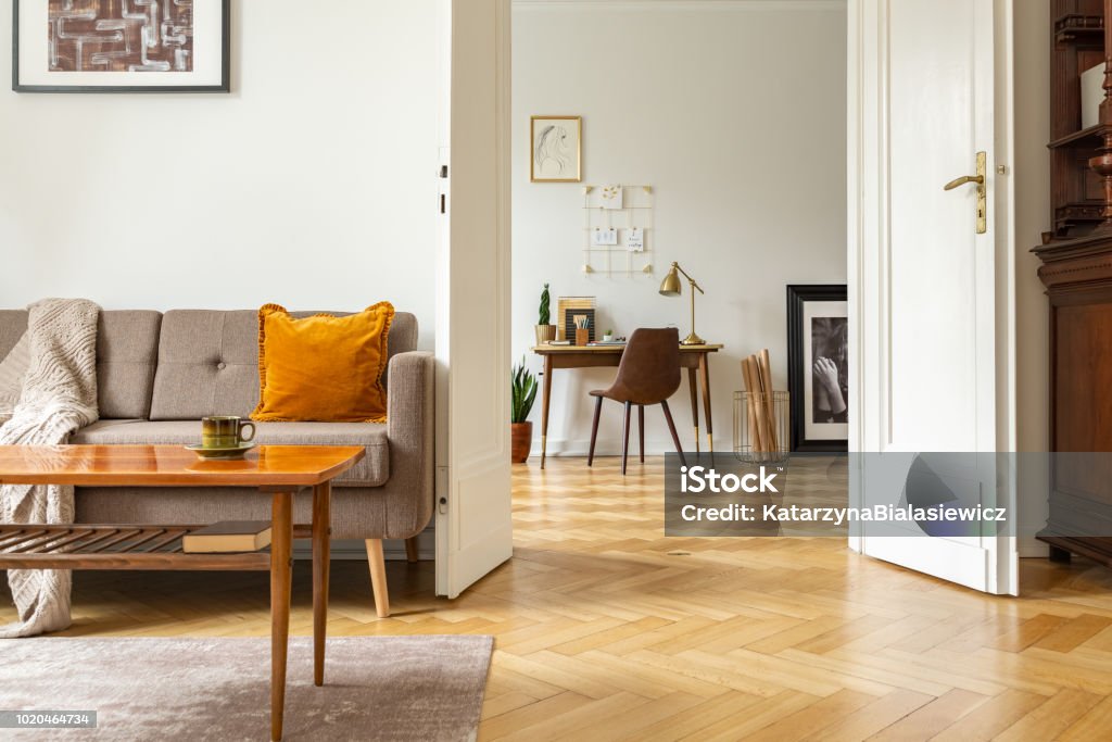 Real photo of a retro living room interior and view of a home office. View through a door Indoors Stock Photo