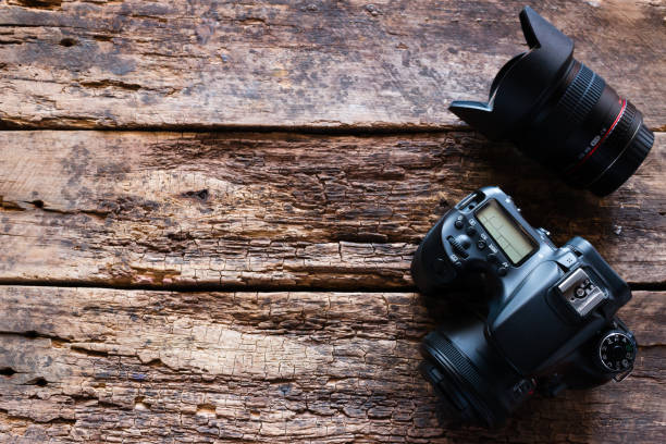 istock photo camera and lens on a wooden background with space for text 1020468490