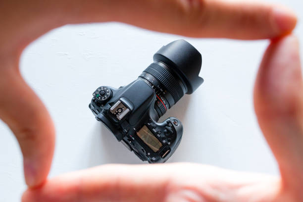 istock photo camera in a frame of fingers on a white background 1020468554