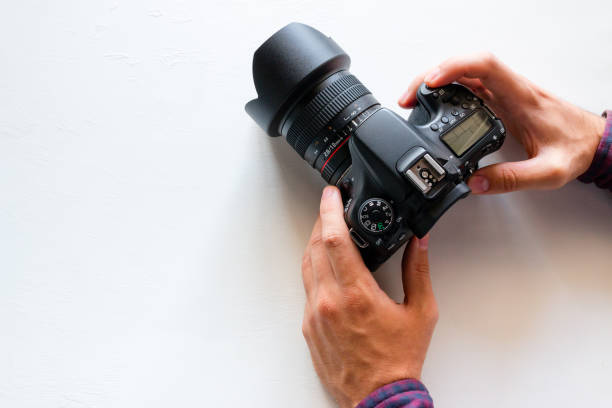 istock photographer with his photo camera on a white background with space for text. World Photography Day 1020480914
