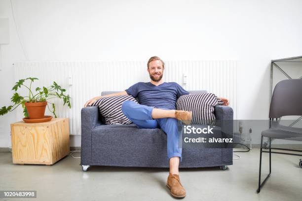 Foto de Médio Empresário Adulto Relaxando No Sofá e mais fotos de stock de Sofá - Sofá, Homens, Sentar