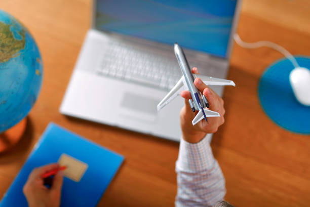 istock Booking a flight with aircraft scale model at home. 1020489448