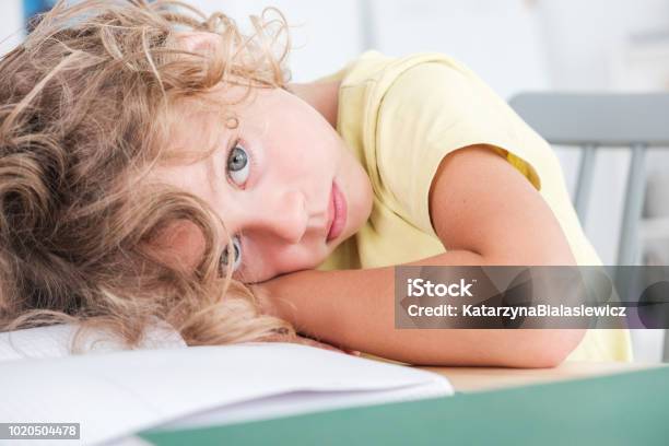 Sad And Lonely Kid Lying His Head On A Desk Stock Photo - Download Image Now - Child, Illness, Autism