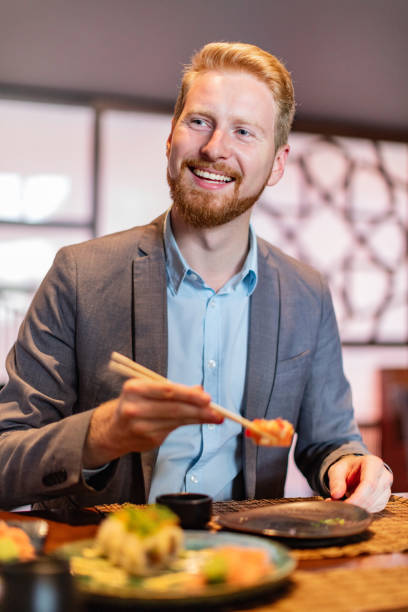 istock Man eating sushi with chopsticks 1020505466