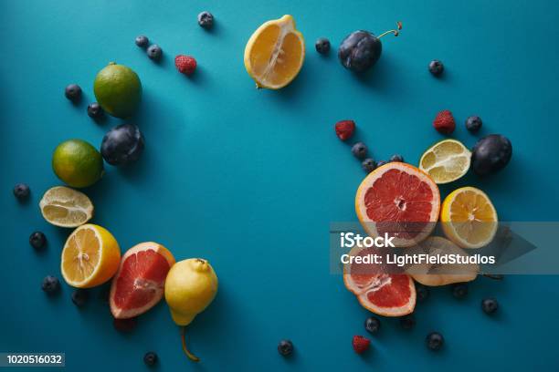 Top View Of Organic Ripe Fruits And Berries On Blue Surface Stock Photo - Download Image Now