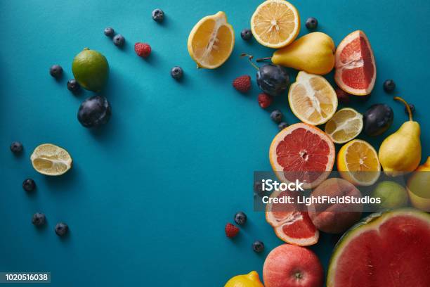 Elevated View Of Appetizing Ripe Fruits And Berries On Blue Surface Stock Photo - Download Image Now