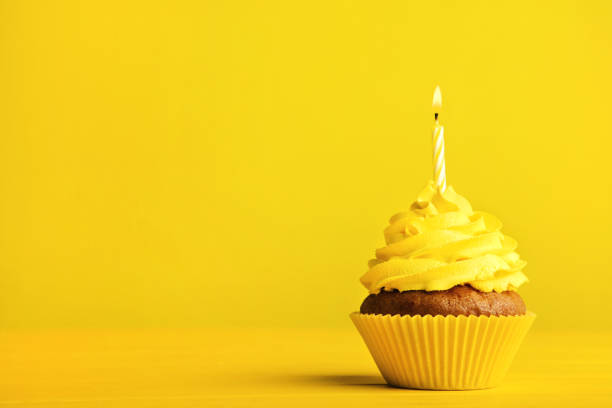 istock Tasty cupcake with candle on yellow background 1020519128