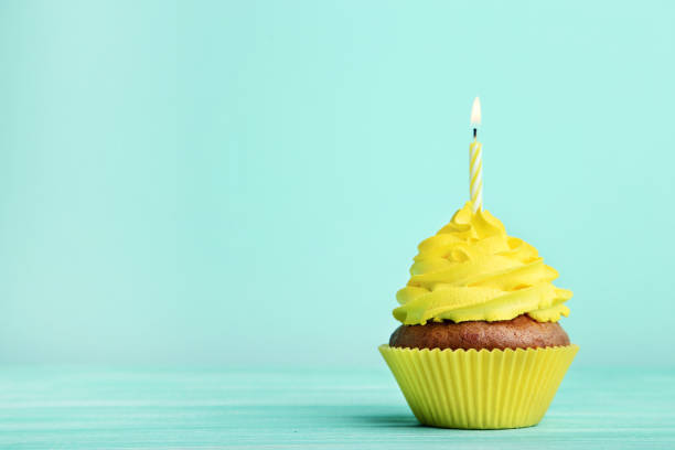 istock Tasty cupcake with candle on mint background 1020519418
