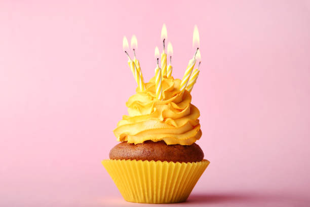 istock Tasty cupcake with candles on pink background 1020519504