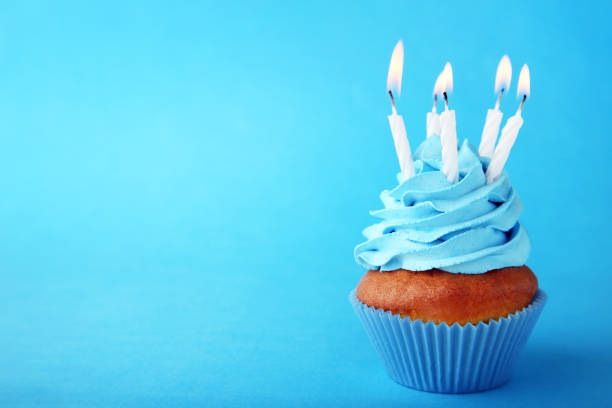 istock Tasty cupcake with candles on blue background 1020519746