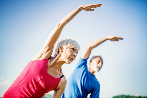 joga seniorów. - exercising stretching women outdoors zdjęcia i obrazy z banku zdjęć