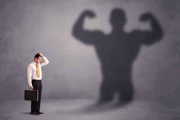 istock Business man looking at his own strong fit shadow concept 1020527554