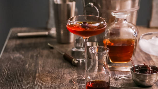 манхэттенский коктейль, украшенный фирменной вишней. - manhattan cocktail cocktail drink cherry стоковые фото и изображения