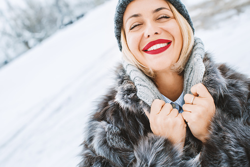 Blonde woman enjoying winter time. Side view. Horizontal. Tilted.