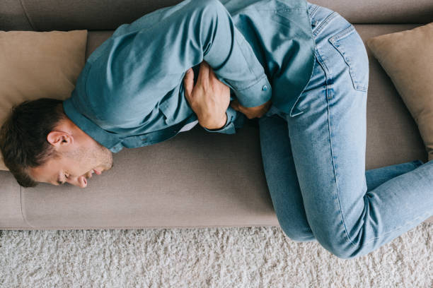 istock top view of man lying on sofa and suffering from stomach ache 1020548258