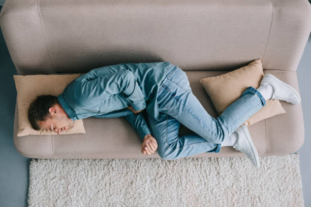 istock top view of man lying on sofa and suffering from abdominal pain 1020548266
