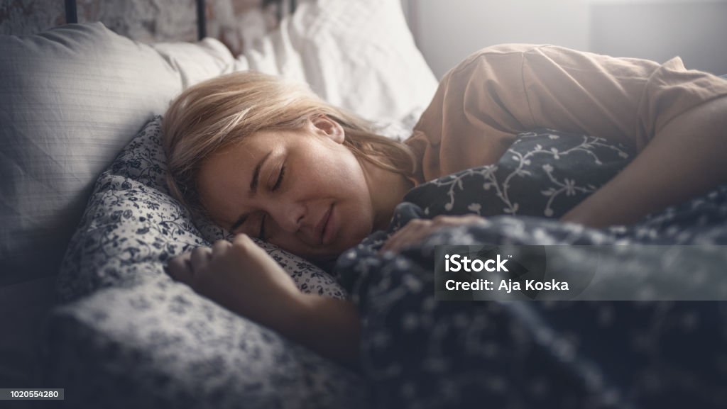 Weekend home activities. Attractive blonde woman peacefully sleeping. Side view. Horizontal. Sleeping Stock Photo