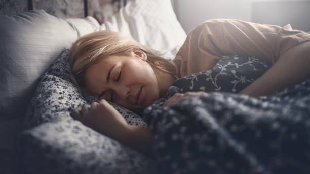 Weekend home activities. Attractive blonde woman peacefully sleeping. Side view. Horizontal. bedtime stock pictures, royalty-free photos & images