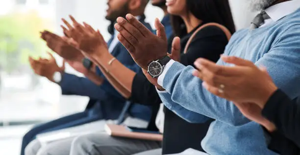 Cropped shot of a group of businesspeople sitting in line and clapping