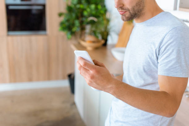 istock cropped image of man using smartphone at kitchen 1020566216