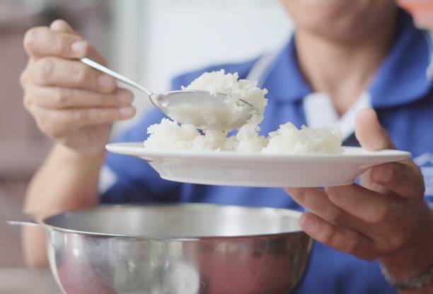 istock People are scooping steam rice from a stainless steel pot on a plate 1020566966