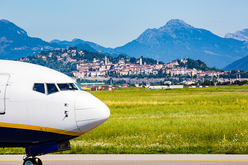 Bergamo, Italy -23 July 2018:Here we can see an aircraft Ryanair  who are about to take off in Bergamo, Orio al Serio airport near Milan-Italy. We can also see in the background the old town of Bergamo, called upper town with its mountain