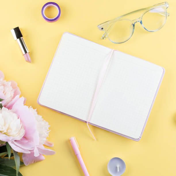 istock Flat lay home office desk. Feminine workspace with open blank note book, peony flowers, eyeglasses. 1020581480