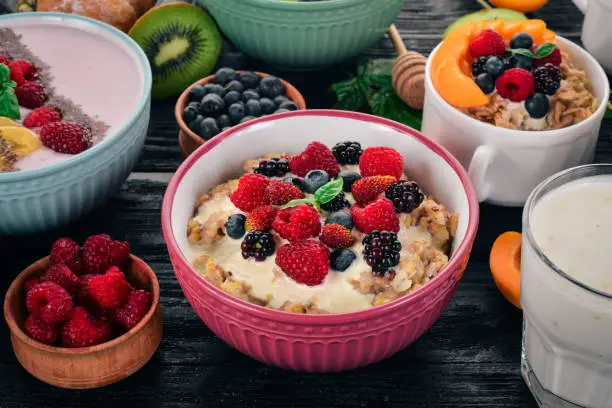 Oatmeal with yogurt and berries. Healthy food. On a wooden background. Top view. Free space for text.