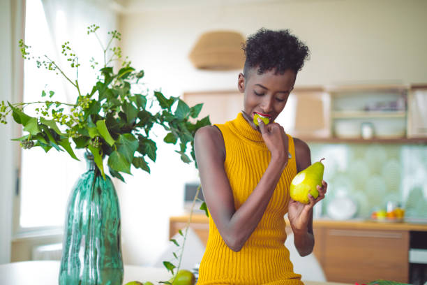 istock Young woman is eating a pear at home 1020582460