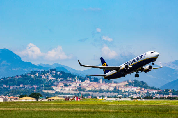 Ryanair airplane Bergamo, Italy -23 July 2018:Here we can see a ryanair Plane that is taking off in the airport of Bergamo- Orio al Serio near Milan-Italy. We can also see in the background the old town of Bergamo, called upper town with its mountain bergamo stock pictures, royalty-free photos & images