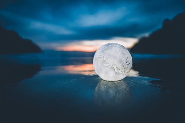 an LED light moon lamp at the beach during sunset