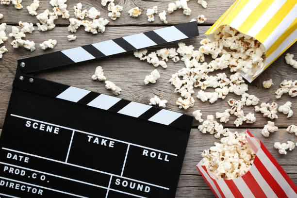 istock Clapper board with popcorn in paper bags on wooden table 1020597552