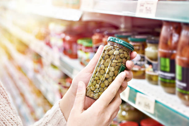 istock Hands with can of canned capers in store 1020605260